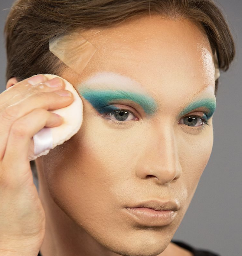 Miss Fame using a beauty puff