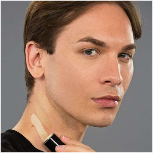 Miss Fame swiping foundation on his neck