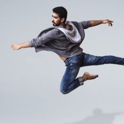 A man in casual clothing leaping through the air