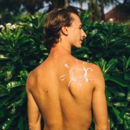 A man with sun shaped sunscreen on his back