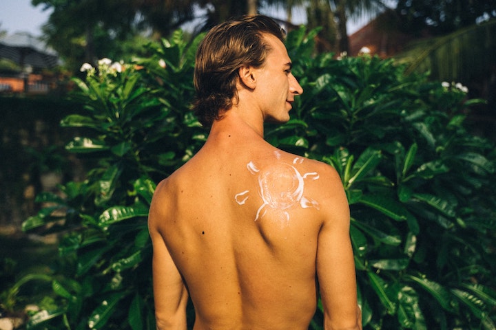 A man with sun shaped sunscreen on his back