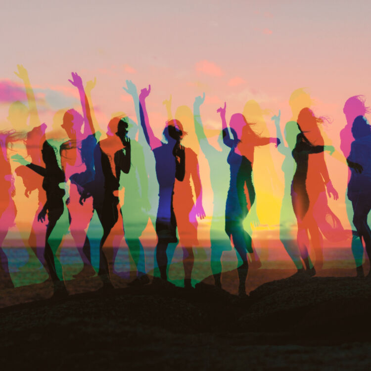 Silhouettes of people dancing on a beach dune at sunset